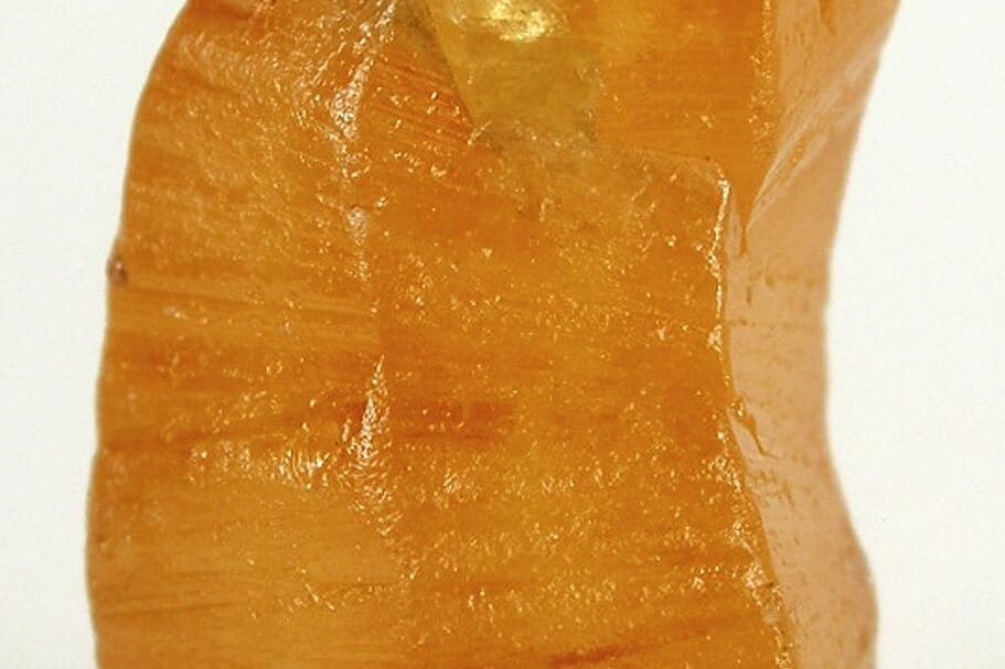 Natural yellow sapphire crystal or mineral specimen in close catalogue view.